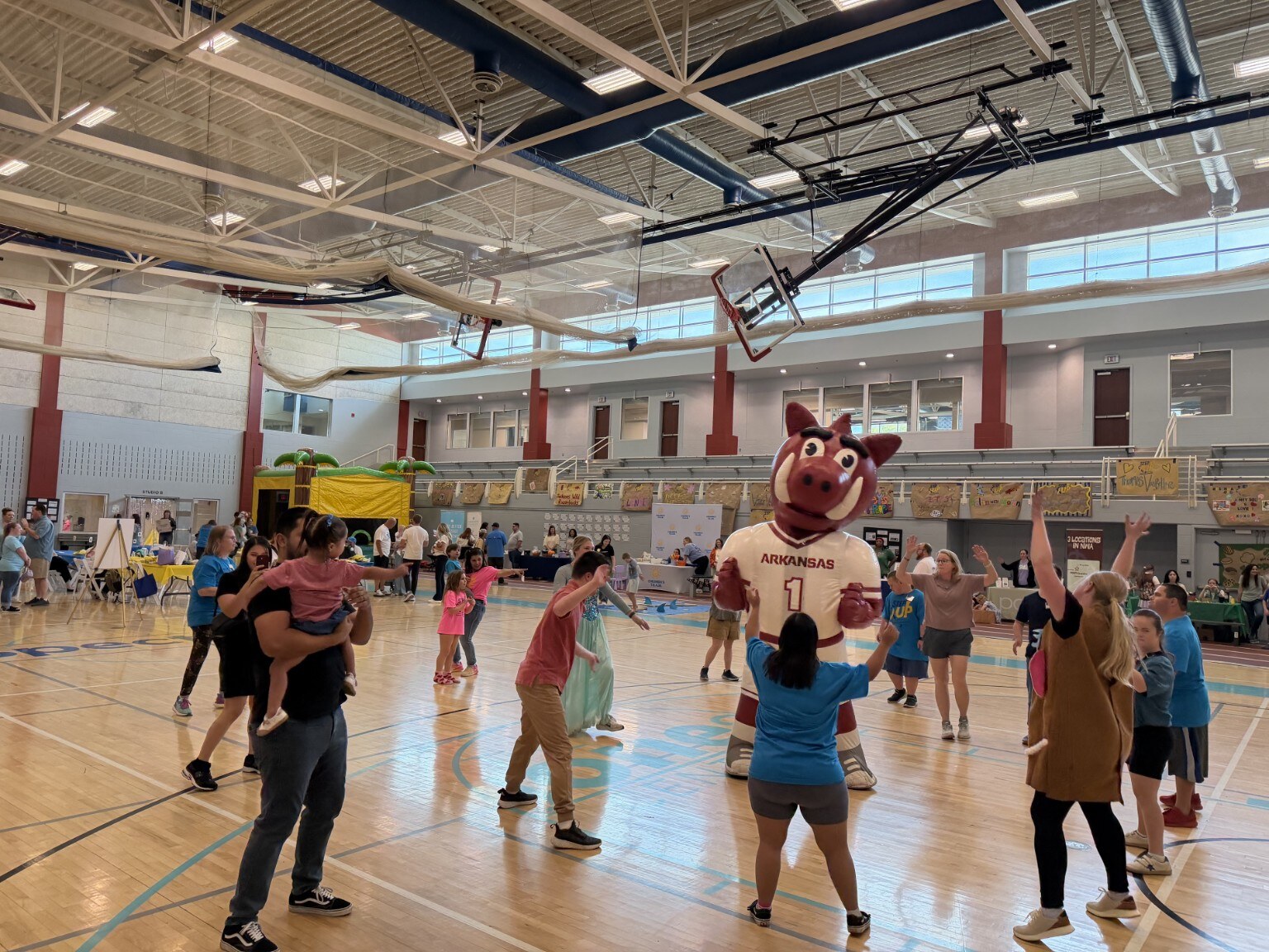 Guests dance alongside a Razorback mascot at the Jones Center in Springdale
