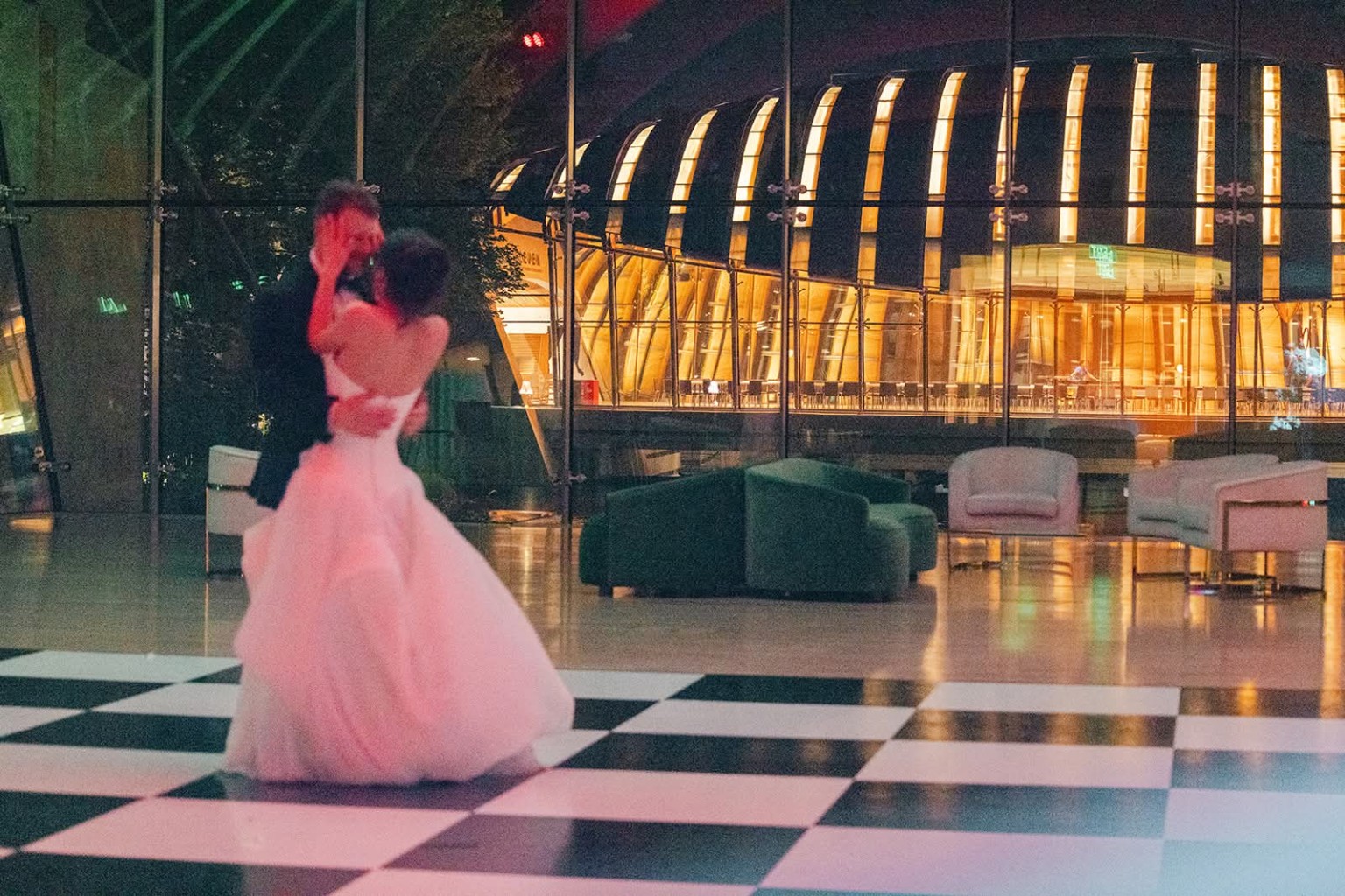 Newlyweds sharing a first dance on a black and white dance floor at a wedding reception